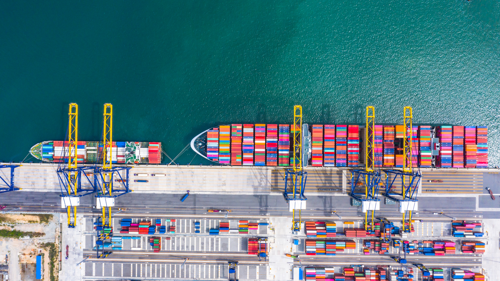 Container ship loading and unloading in deep sea port, Aerial top view of business logistic import and  export freight  transportation by container ship in open sea.